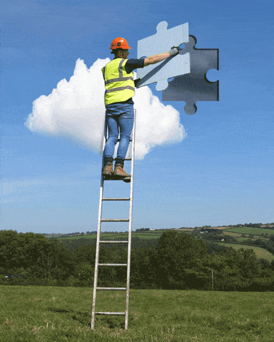 Construction working putting a puzzle piece on the wall GIF