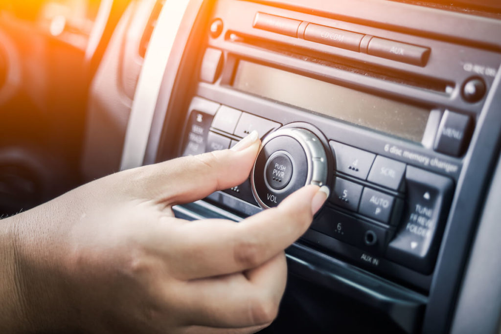 Radio commercials: person turning the dial of a car radio
